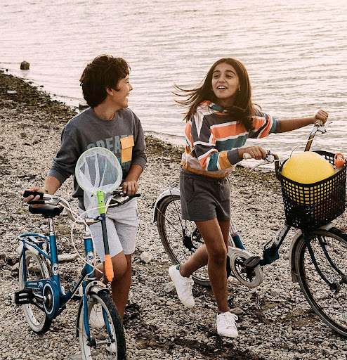 усмихнати деца добре облечени с колело